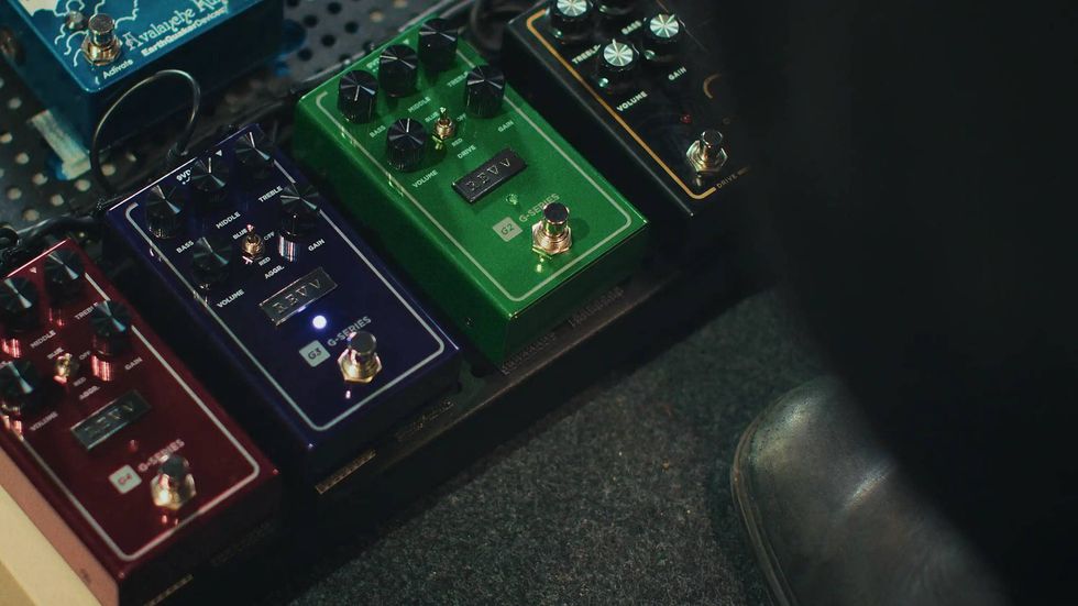A close-up of multiple guitar effects pedals arranged on a pedalboard.