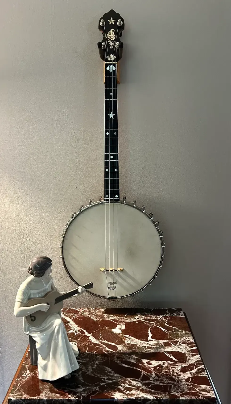 A decorative banjo hangs on the wall, beside a small figurine playing a guitar.