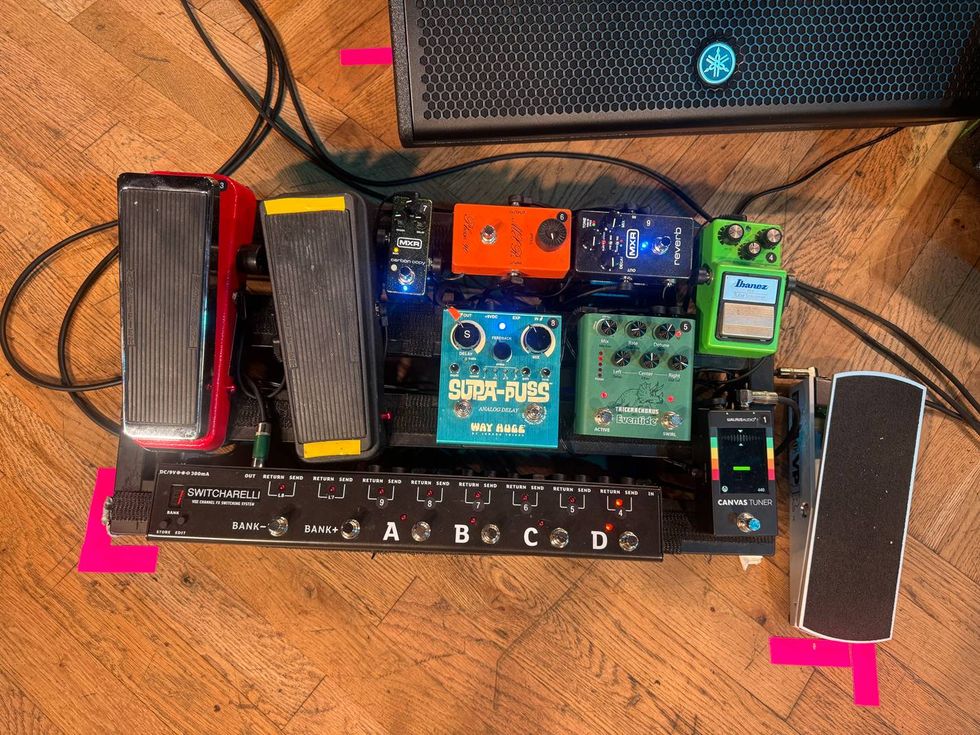 A guitar pedalboard featuring various effects pedals and two expression pedals.
