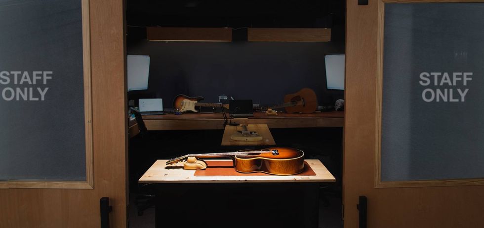 A music studio entrance displaying instruments and "STAFF ONLY" signs on glass doors.