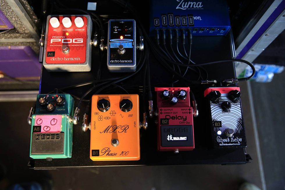 A selection of guitar effects pedals neatly arranged on a black pedalboard.