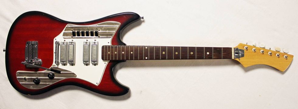 A vintage electric guitar featuring a glossy red finish and multiple pickups.