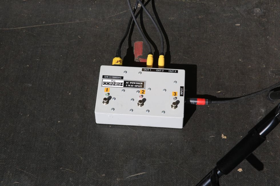 AC powered 3-way splitter with multiple input and output connections on a dark surface.