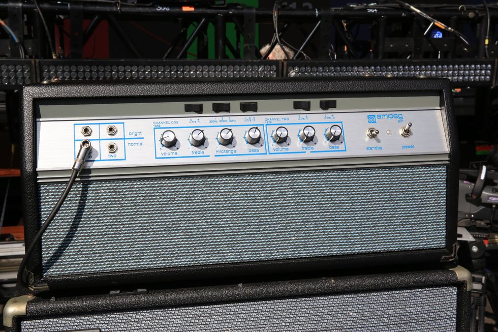 Ampeg amplifier head with control knobs for volume, treble, midrange, and bass.