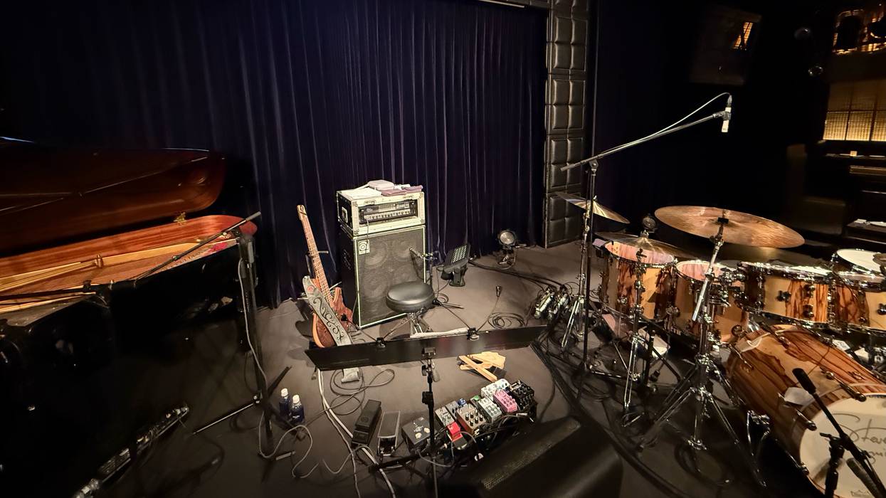 Blue Note Tokyo stage setup with a grand piano, drums, and musical equipment.
