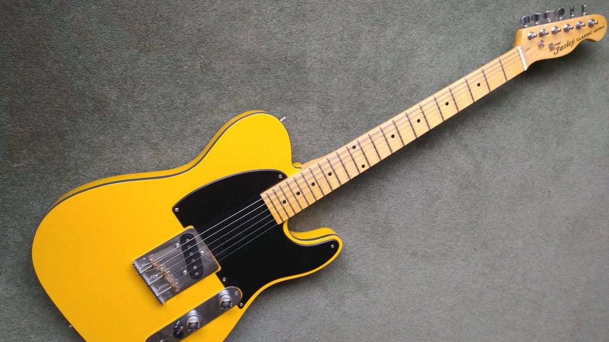 Bright yellow electric guitar with a black pickguard and maple neck on a gray background.