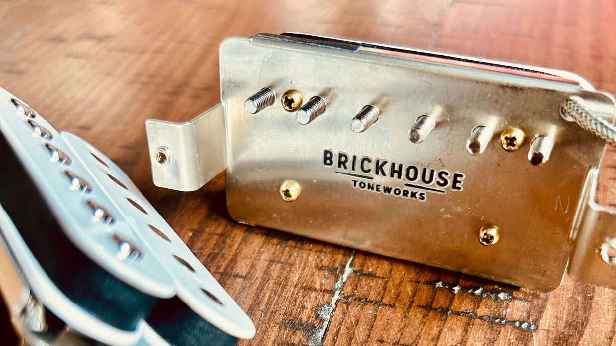 Close-up of a Brickhouse Toneworks guitar pickup, with screws on a wooden surface.