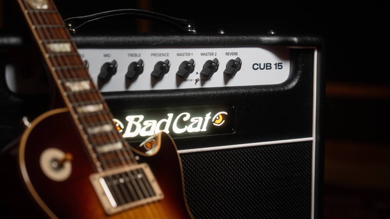 Close-up of a guitar and a Bad Cat CUB 15 amplifier, showcasing control knobs and logo.