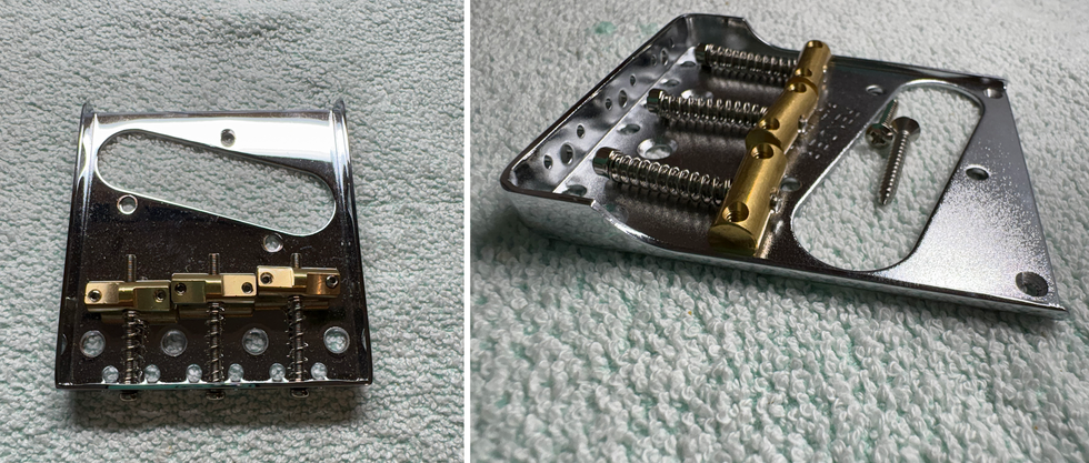 Close-up of a metallic guitar bridge with golden hardware and screws, resting on a soft surface.