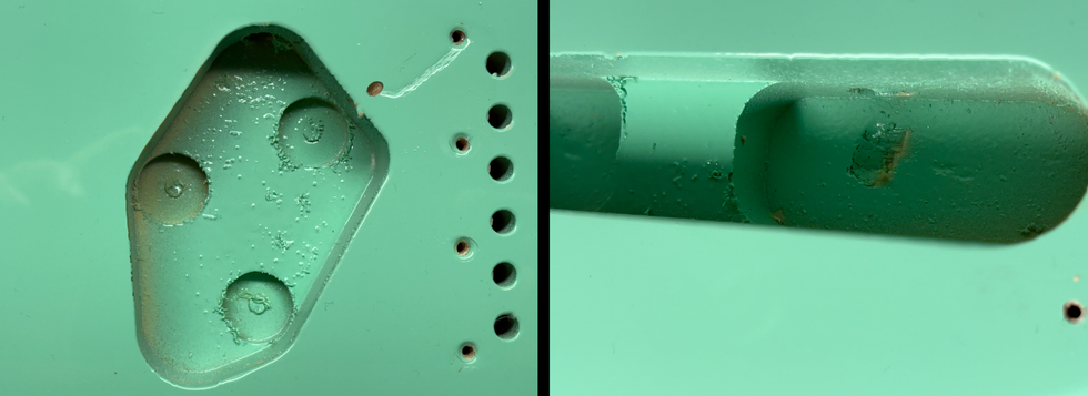 Close-up of a mint green metallic surface with indentations and holes.