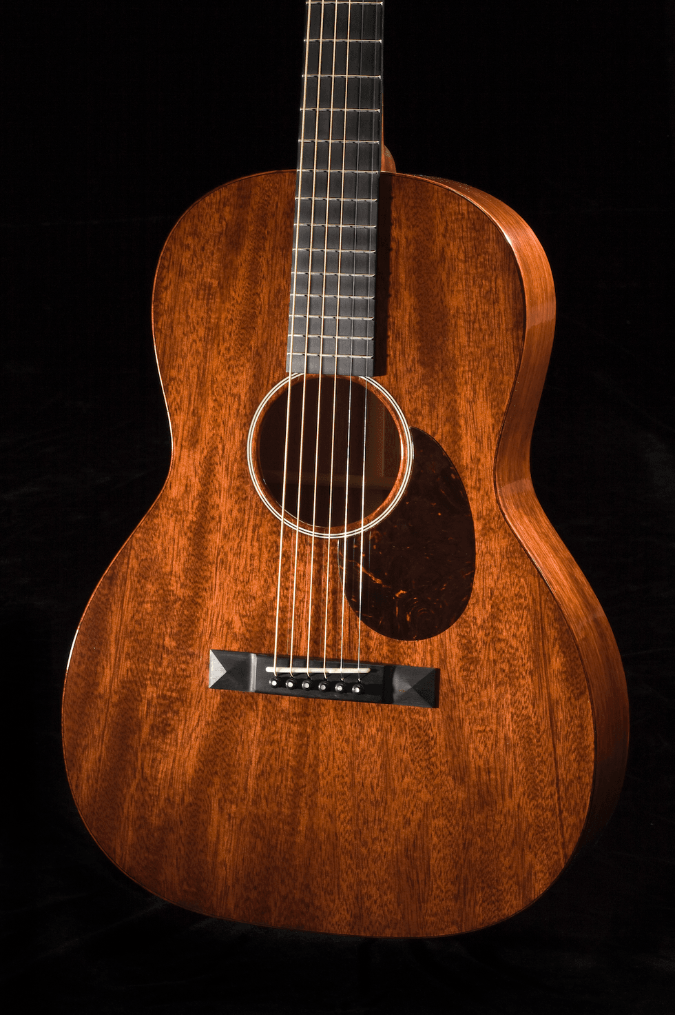 Close-up of a wooden acoustic guitar with a rich finish and distinctive grain patterns.