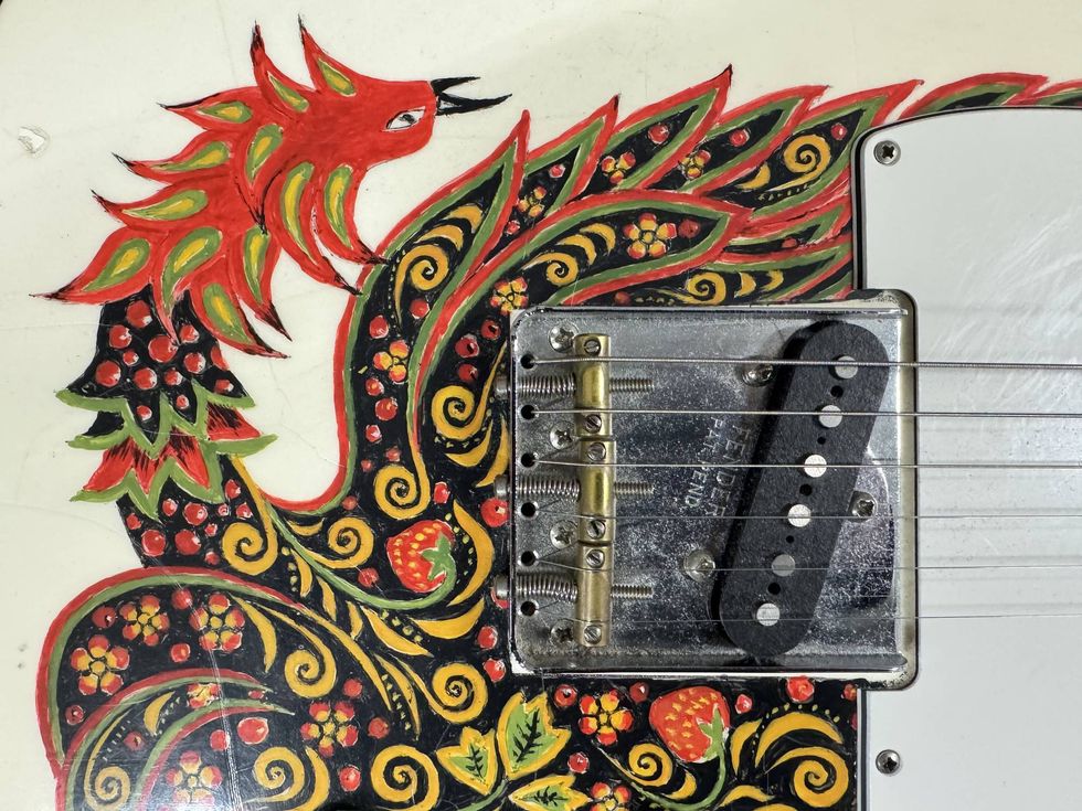Colorful hand-painted guitar body featuring a phoenix design and floral details.