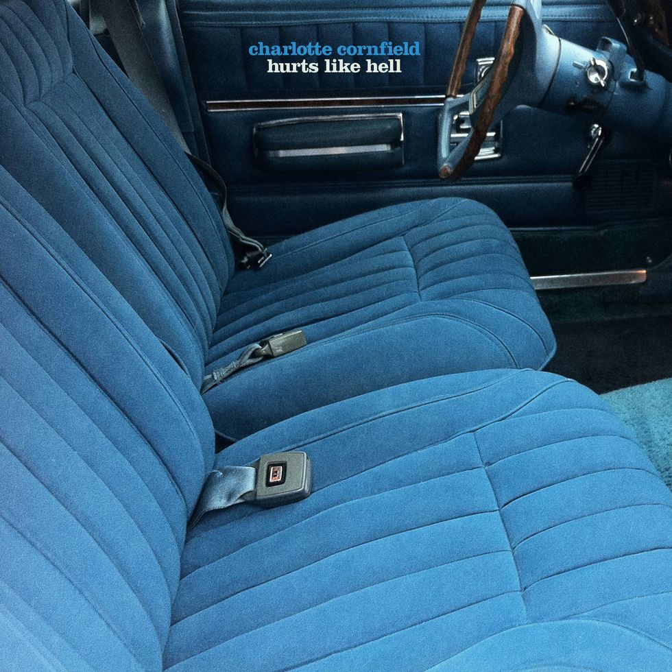 Interior of a vintage car featuring plush blue seats and a classic steering wheel.