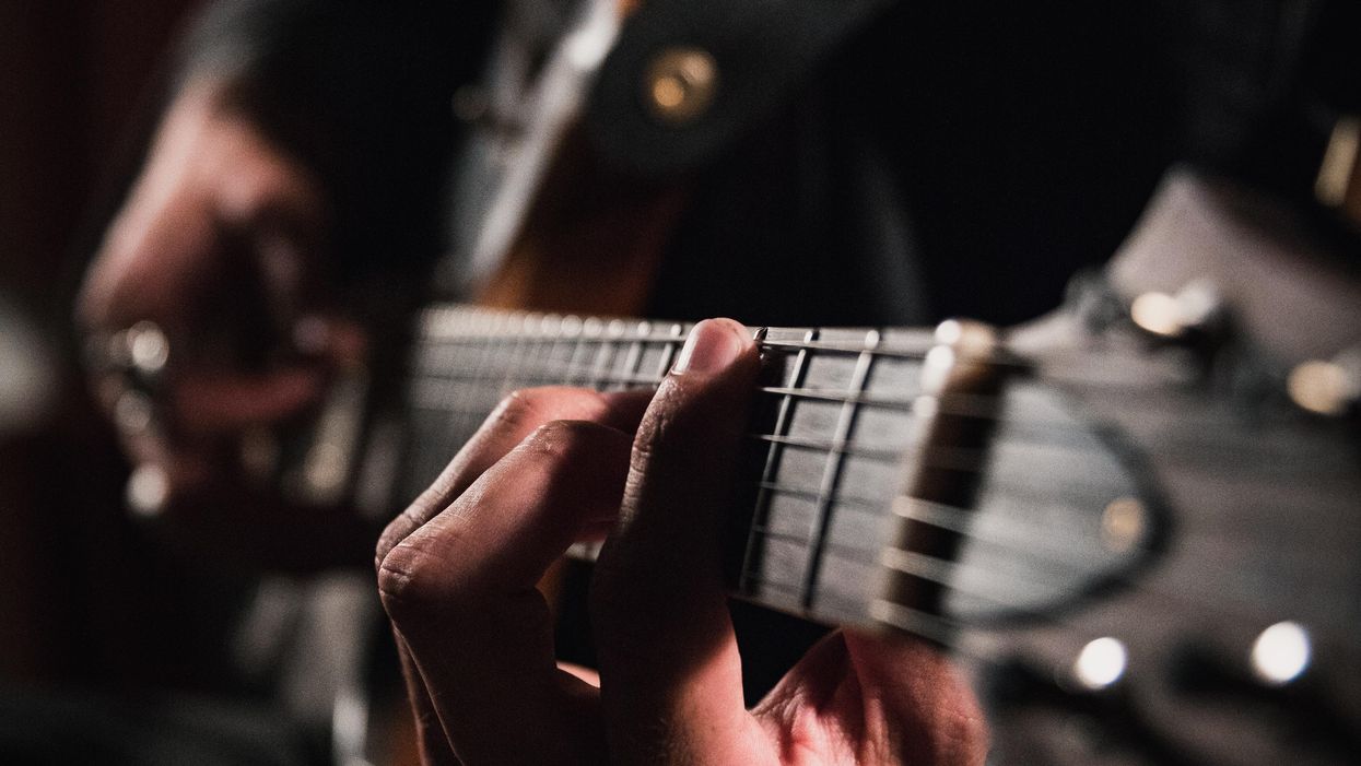 man playing guitar in close up photography