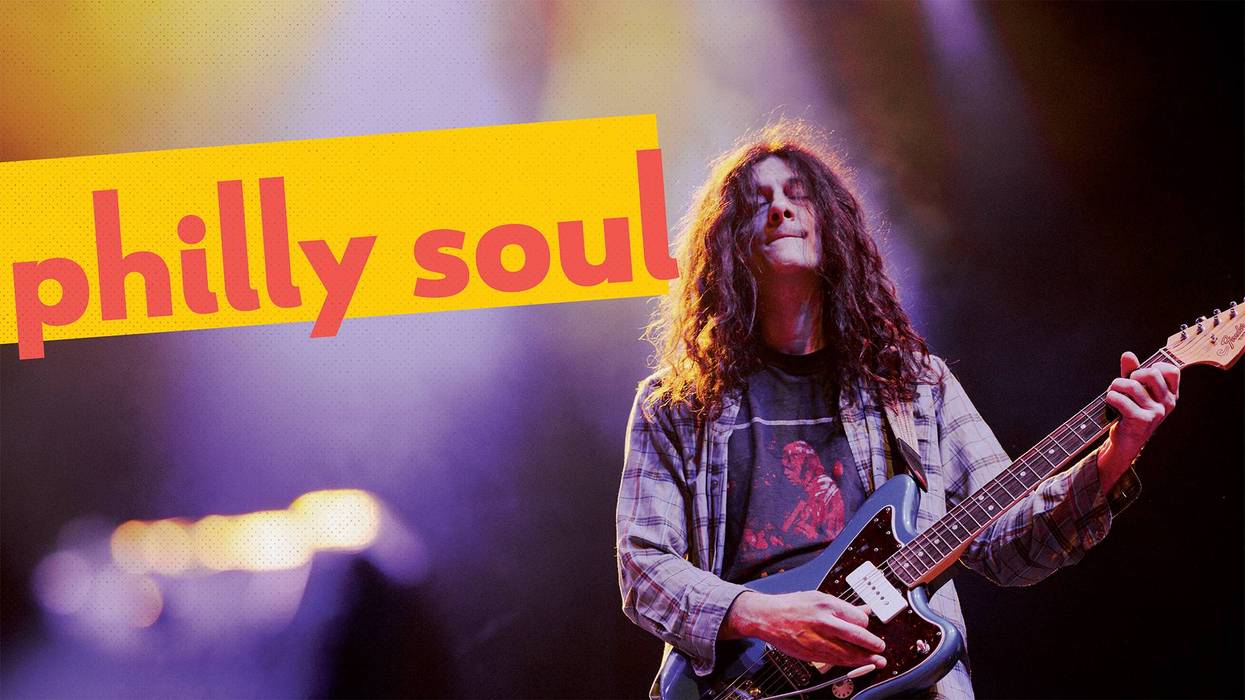 Musician playing guitar on stage with vibrant lights and "philly soul" text overlay.