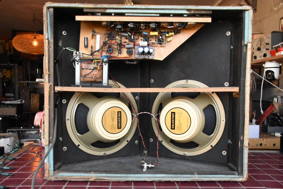 Open audio amplifier with two Celestion speakers and visible circuitry inside.