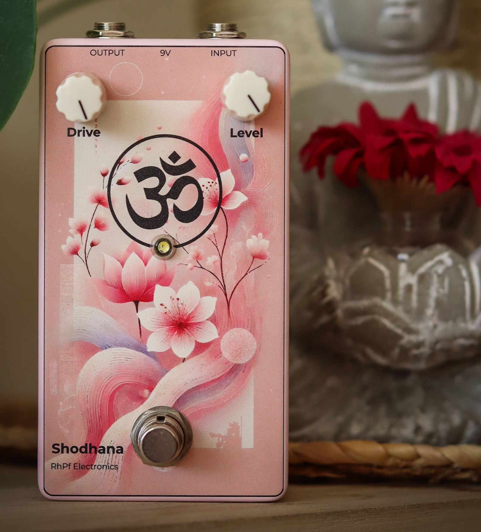 Pink guitar effects pedal with floral design, featuring Drive and Level knobs.