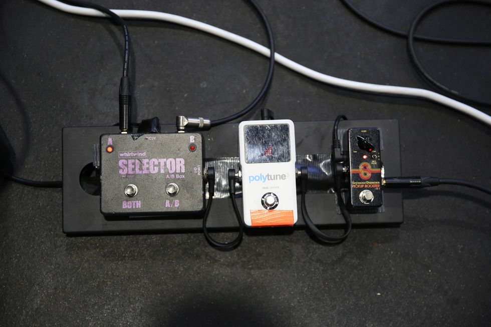 Three guitar effects pedals arranged on a black pedalboard with cables connected.