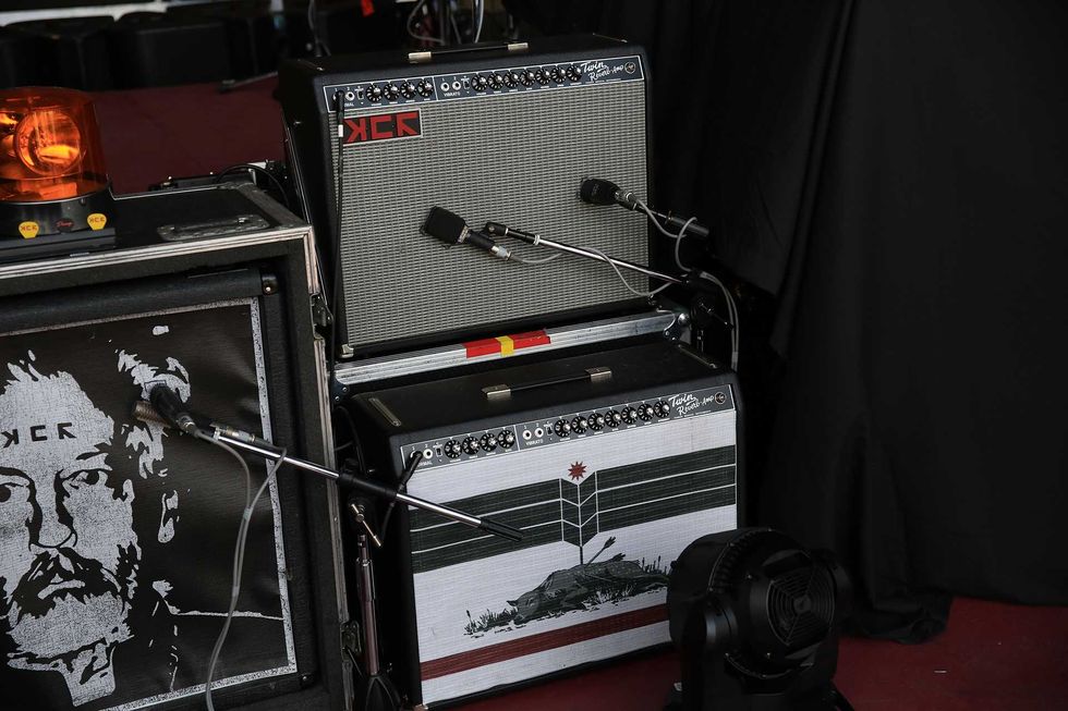 Two guitar amplifiers with unique designs, accompanied by a fan and a warning light.