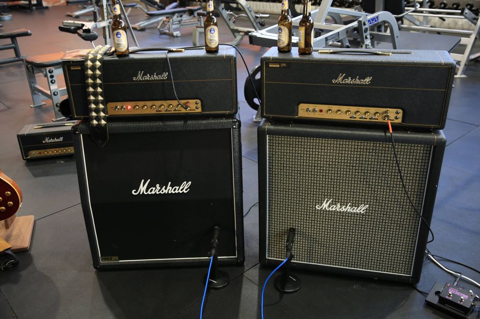 Two Marshall guitar amplifiers with beer bottles on top, set in a gym environment.