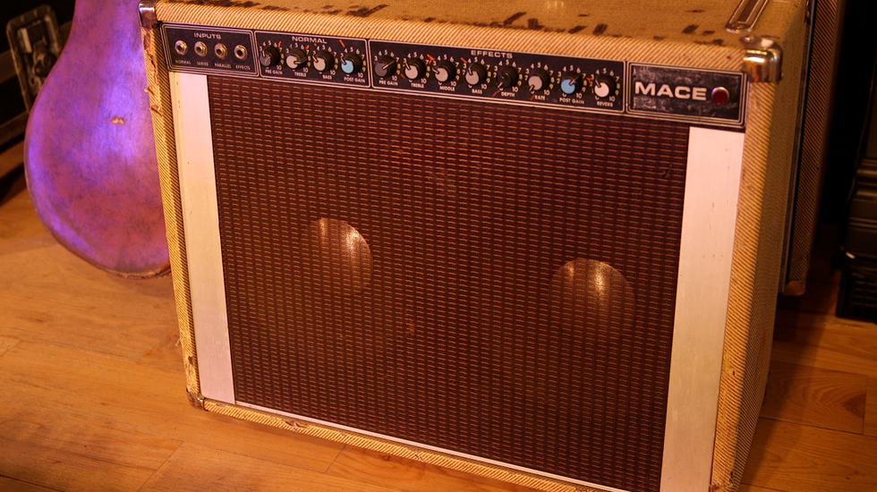 Vintage Mace guitar amplifier with dials and fabric grille, resting on a wooden floor.