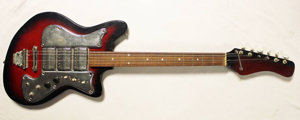 Vintage red and black electric guitar with a unique body shape and metallic hardware.