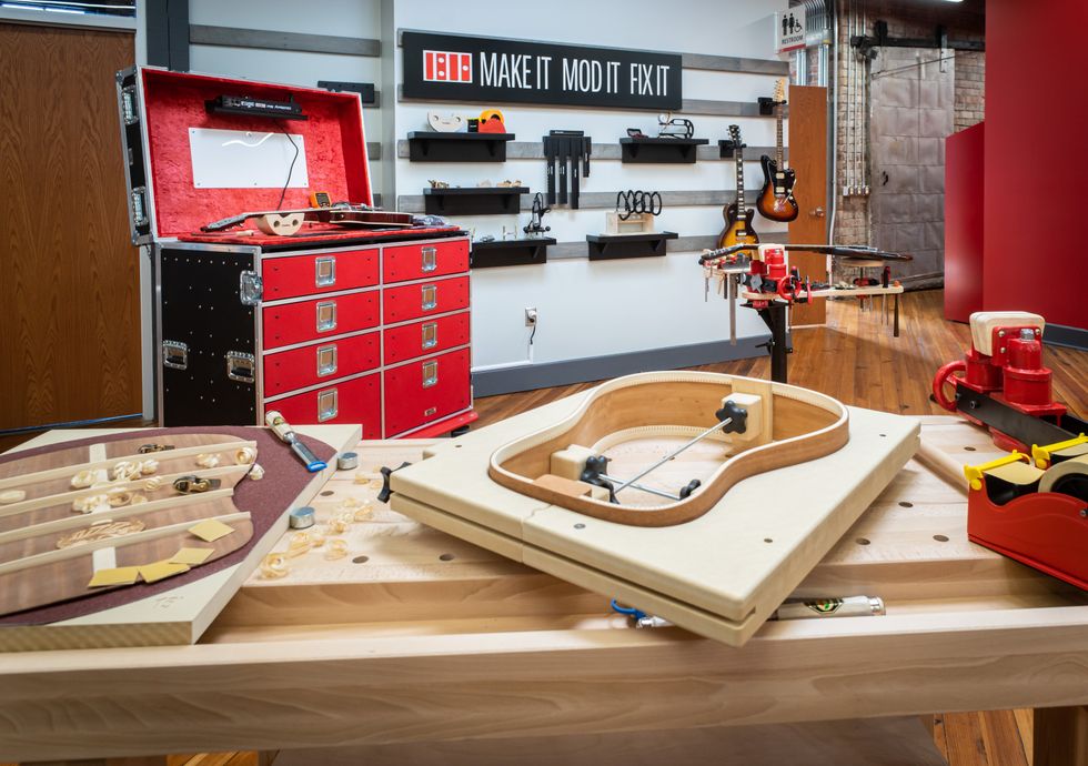Workshop scene featuring tools, guitar components, and a "Make It Mod It Fix It" sign.